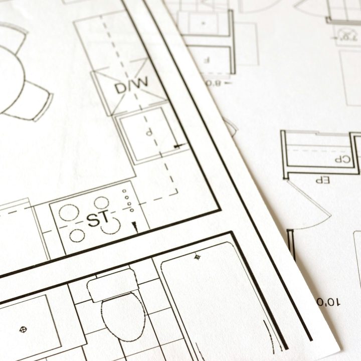 Close-up view of an architectural floor plan on paper showcasing detailed room layouts and measurements.